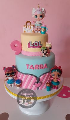 there is a birthday cake with toys on the top and bottom tier that says, lol surprisers tarra