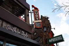 the outside of a building with signs for shops and restaurants on it's side