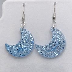 Light Baby Blue Sky Blue Sparkle and Glitter Dangle Earring Moon Shape Trendy Glamor Fashion Statement - Gender Reveal Gift by CypressWoodsArt on Etsy Blue Moon Shaped Earrings With Moon Charm, Blue Dangle Earrings With Moon Charm, Blue Round Earrings With Moon Charm, Blue Moon-shaped Earrings With Moon Charm, Blue Crescent Moon Charm Earrings, Blue Resin Jewelry For Party, Blue Resin Jewelry For Parties, Blue Celestial Round Earrings, Blue Moon Charm Earrings