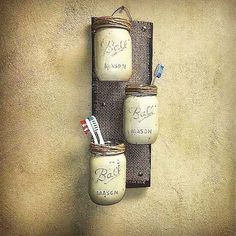 three mason jars are hanging on the wall