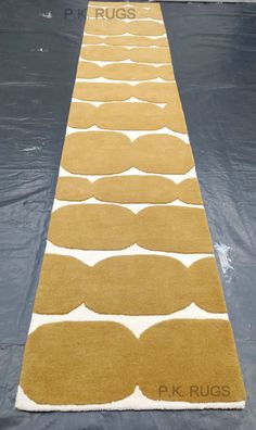 a long yellow and white rug on top of a black floor with the words pk rugs