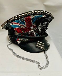 This is a black leatherette captain hat. Well made to a high standard. It has plenty of eye catching detail including metal studs, safety pins and Union Jack  , please refer to photos . It also has a metal chain, This is a size 59 cm which fits most size heads. No two hats are created the same. Individual and unique  Thank you for looking Adjustable Punk Mini Hat For Cosplay, Adjustable Punk Top Hat For Halloween, Punk High Crown Top Hat For Festivals, Adjustable Punk Mini Hats For Halloween, Punk High Crown Mini Hats For Halloween, Punk Style Mini Hat With High Crown For Party, Adjustable Gothic Costume Hats For Festivals, Punk Style High Crown Mini Hat For Party, Adjustable Gothic Festival Costume Hats And Headpieces