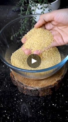 a person is sprinkling seeds into a glass bowl