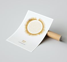 a white and gold brochure with an image of a circular design on it