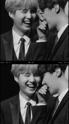 black and white photo of two boys in suits laughing at each other's faces