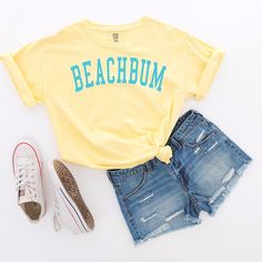 This slightly minimalist BEACHBUM graphic tee is perfect for a day at the beach, by the lake, poolside or just to celebrate the summer season. Beachbum varsity letters design is printed on your favorite comfort colors tee.  Are you looking for your new favorite t-shirt? Our graphic tees are custom created specifically for you and made by me not sourced out to a print shop. Select your shirt style, color, and print design. Your item will be created using direct-to-garment (DTG) print technology. Casual Yellow T-shirt For Vacation, Crew Neck Beachwear T-shirt For Poolside, Yellow Short Sleeve Tops For Beachwear, Yellow Short Sleeve Beachwear Top, White Crew Neck Top For Poolside, Summer Crew Neck T-shirt For Poolside, Beachy Crew Neck Top For Poolside, Crew Neck Tops For Poolside, Beachwear Style, Poolside Crew Neck Tops For Beachwear