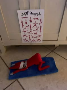 a cat in the hat is laying on a towel next to a sign that says elf yoga