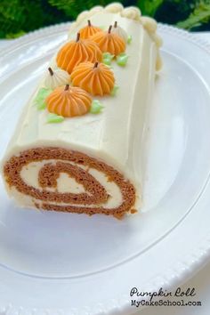 a piece of cake on a white plate with pumpkins in the center and leaves