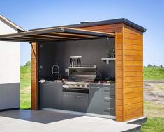 an outdoor kitchen is built into the side of a house with a grill and sink