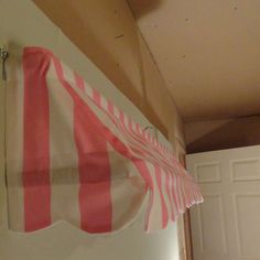 a red and white striped curtain hanging from the side of a door