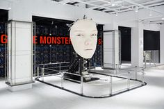 a large white mask sitting on top of a metal frame in a room filled with mirrors