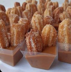 several desserts are arranged in small trays on a white tablecloth with brown icing