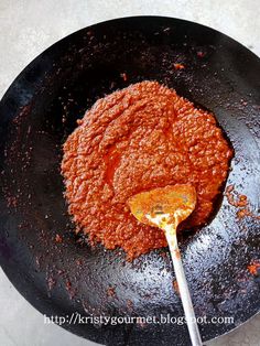 a frying pan filled with sauce on top of a table