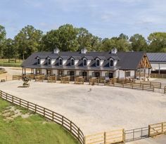 a horse farm with several stalls and fences