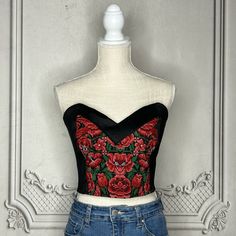 a mannequin wearing a black and red top with roses on it's chest