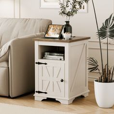 a living room with a couch, table and potted plant on the floor next to it