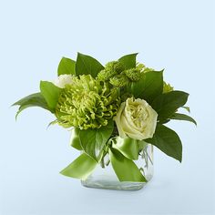 a vase filled with green and white flowers