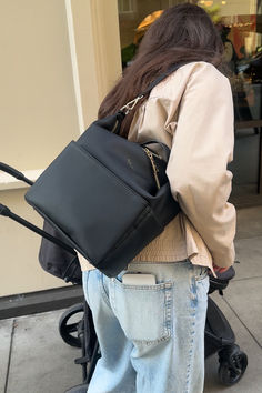 a woman carrying a black purse on her back