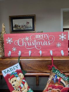 two christmas stockings hanging from a mantle with merry christmas signs on it and teddy bears