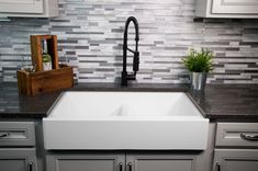 a white kitchen sink sitting under a faucet in front of a counter top