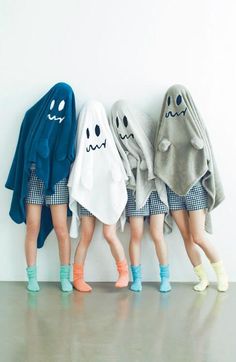 three girls in halloween costumes standing next to each other with ghost towels on their heads