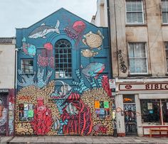 a mural on the side of a building with fish and octopuses painted on it