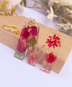 three glass vases with flowers in them sitting on a table