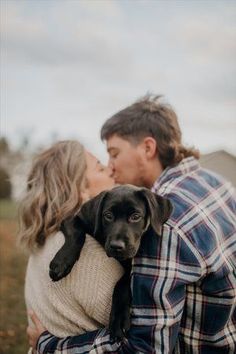 a man and woman kissing with a dog