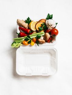 two plastic containers filled with different types of vegetables