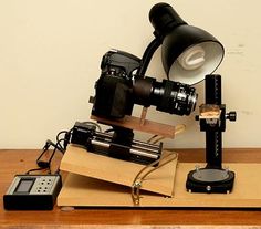 an old fashioned camera is on top of a wooden table next to a projector