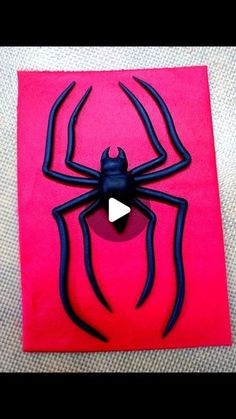 a paper sculpture of a spider on a pink background