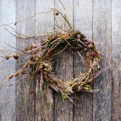 a wreath made out of twigs and other plants on a wooden surface with no leaves