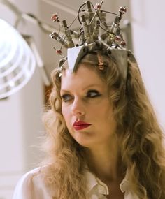 a woman with long hair wearing a head piece made out of wires and screws