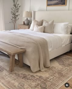 a bedroom with a large bed and rugs on the floor