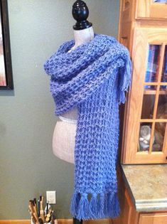 a blue knitted scarf hanging on a mannequin's dummy in a kitchen