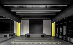 an empty parking garage with yellow lights on the ceiling and black walls, along with benches