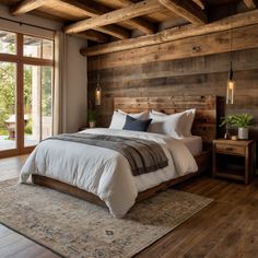 a bedroom with wooden walls and flooring has a large bed in the center, along with two nightstands on either side