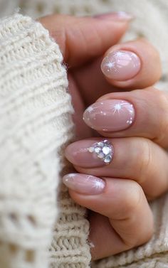 a woman's hand with pink and white manicures holding onto her sweater