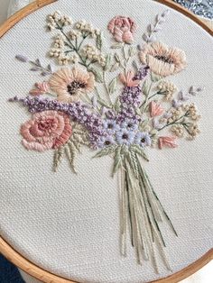 a close up of a embroidery on a piece of cloth with flowers in the middle