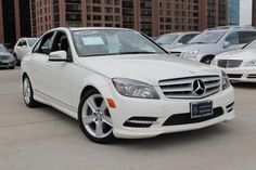 a white mercedes c - class parked in a parking lot