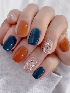 cute fall Korean nails: dark blue and burnt orange jelly nails with glitter Short Blue And Orange Nails, Blue And Orange Gel Nails, Autumn Blue Nails, Dark Blue And Orange Nails, Blue And Orange Nail Ideas, Orange And Blue Nails Design, Fall Inspired Nails Autumn, Navy And Orange Nails, Blue And Orange Nails Designs