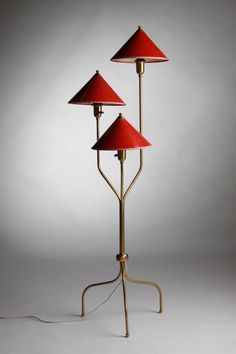 three red lamps sitting on top of a metal stand