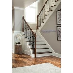 a stair case in a home with hardwood floors and white walls, along with pictures on the wall