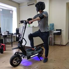 a man is riding an electric scooter in a room with other equipment on the floor