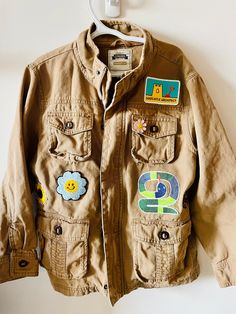 Inspired by nature and adventure. Summer camping trips and scouts! This is a thrifted Gymboree jacket in a size 7/8. I hand painted the back, added patches and a pin for extra personality!  All patches are reinforced with hand stitching. This item can be machine washed on gentle or hand washed.  All jackets are one of a kind. I can recreate this jacket in the size you need but the style and patching will be different. Vintage Cotton Utility Jacket For Outdoor Activities, Vintage Cotton Utility Jacket For Outdoor, Casual Khaki Outerwear With Patches, Outdoor Cotton Outerwear With Logo Patch, Cotton Outerwear With Logo Patch For Outdoor, Casual Outdoor Outerwear With Logo Patch, Casual Outerwear With Logo Patch, Casual Outerwear With Patches For Outdoor, Casual Outdoor Outerwear With Patches