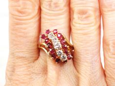 This Vintage 14k Ruby and Diamond Ring is elegant! The ring showcases five round diamonds and fourteen natural rubies in a fancy three row stepped design. The diamonds are round brilliant cuts and range from approximately .15 to .20 carats each for over 3/4 carats of diamonds in total. The diamonds are approximately K-L in color and SI1-SI2 in clarity. The rubies, which are the July birthstone, range in size from approximately 2.5 mm. They are natural and have lovely red color. Each row of gems July Birthstone Ring, Natural Ruby Ring, Jewelry Girl, Ruby And Diamond Ring, Statement Rings Diamond, Diamond Bows, Ruby Diamond Rings, Blue Stone Ring, Right Hand Rings