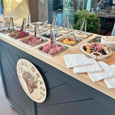 an assortment of meats and cheeses on display at a buffet table in a restaurant