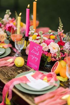 the table is set with pink and yellow flowers