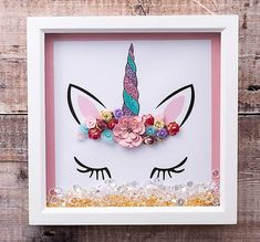 a unicorn's face is surrounded by flowers and sequins in a white frame