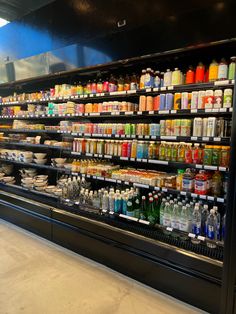 a large display case filled with lots of drinks and condiments in a grocery store